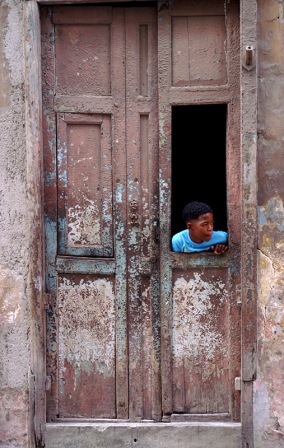 Boy looking out from a door, Havana. Photo by James NG