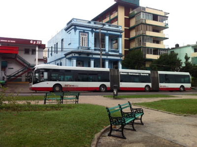 A three-car Metro Bus at its 25th and G St. stop in Vedado. 