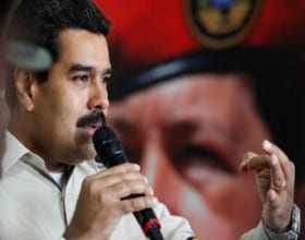 Venezuelan president Nicolas Maduro with a painting of former leader Hugo Chavez in the background. 