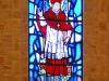 A large stained-glass window to the left of the altar.