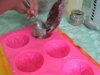 The soap being put in the silicone molds.