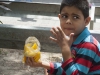 niño comiendo mango con aliños  en bulevar de catia