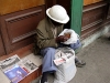 An old construction worker eating croquetas for lunch and selling newspapers. Photo by Anna Arten