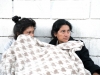 Two women sleeping outside of the camp