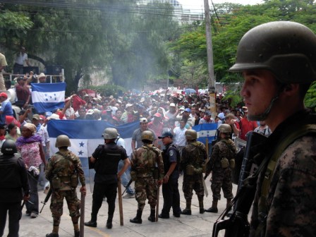 Soldiers and Police eye demonstrators at the Public Building.