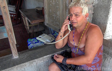 Adela’s office in Cuba is a neighbor’s porch, where there’s a phone for public use.