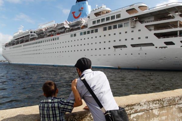 Father and son observe a cruiser in Havana Bay.